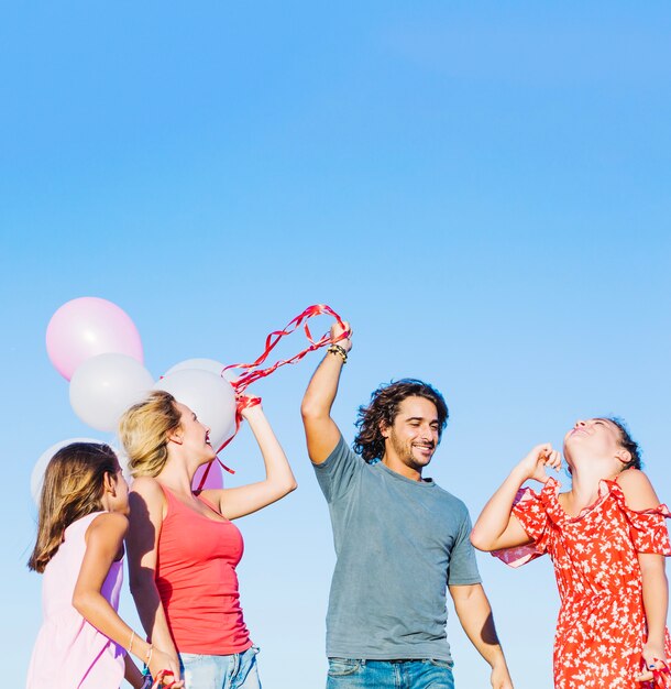 Familia alrededor del hombre con globos