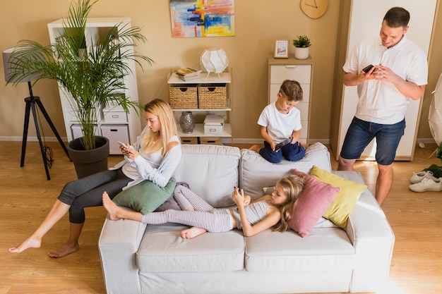 Familia de alta visión que pasa su tiempo en el teléfono móvil