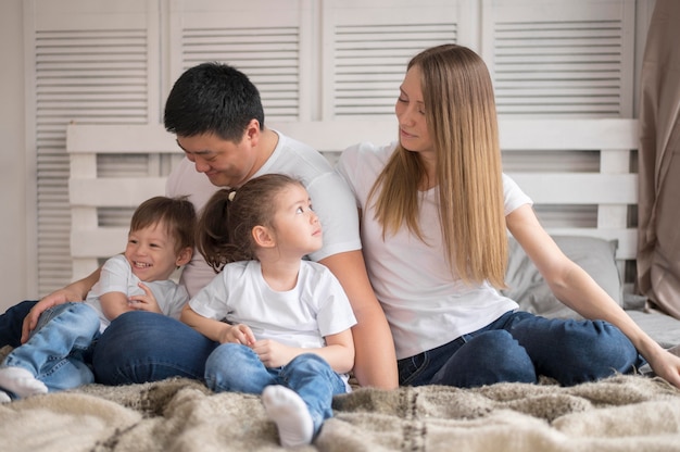 Familia de alto ángulo en casa en la cama