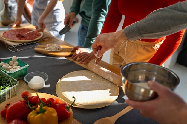 Familia de alto ángulo cocinando deliciosa pizza