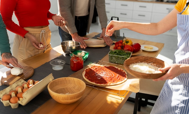 Foto gratuita familia de alto ángulo cocinando deliciosa pizza