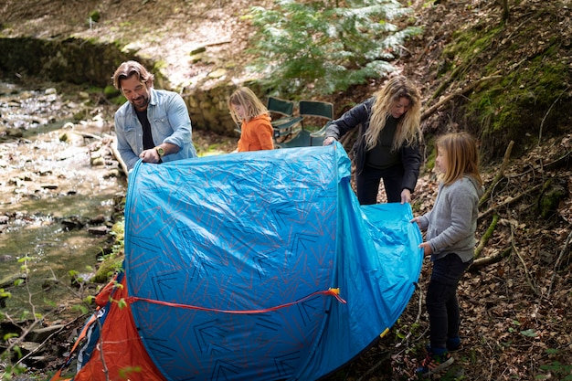 Familia de alto ángulo montando la carpa.