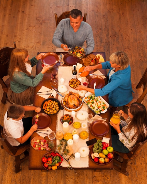 Familia de alto ángulo sentado en la mesa de la cena