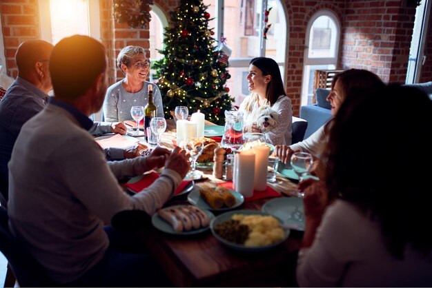 Familia y amigos cenando en casa celebrando la nochebuena con comida tradicional y decoración celebración del invierno festivo