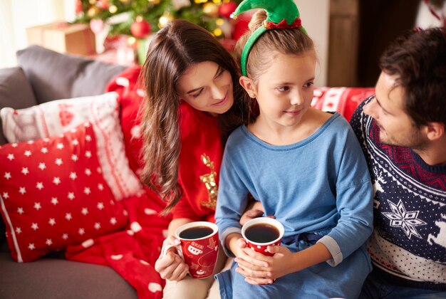 Familia amorosa bebiendo chocolate negro en Navidad