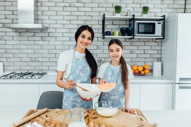 Familia amorosa feliz está preparando panadería junto con harina y huevos