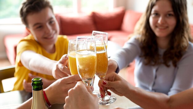 Familia animando con copas de champán en casa