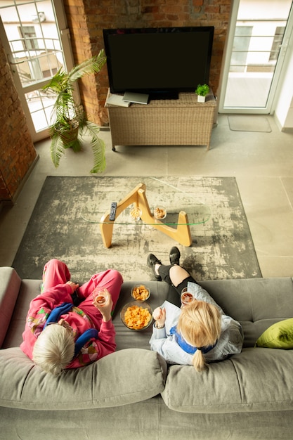 Familia animando y viendo televisión en casa en la sala de estar