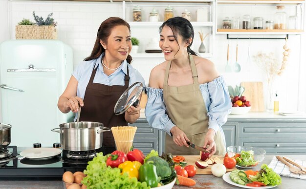 Familia asiática feliz cocinando comida en la cocina en casa Disfrute de la actividad familiar juntos