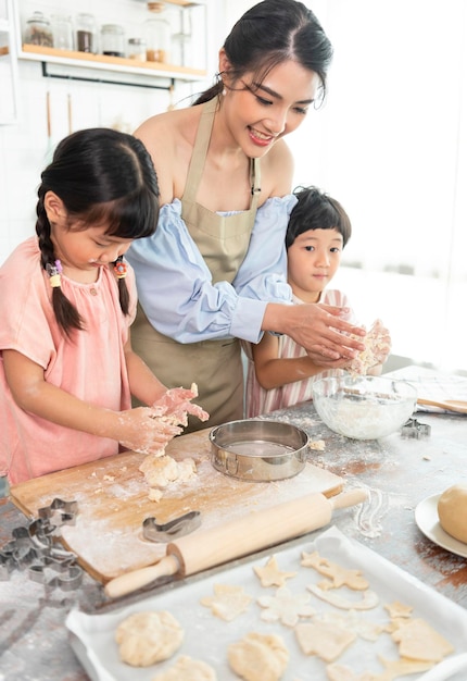 Familia asiática feliz haciendo comida en la cocina en casa Disfrute de la actividad familiar juntos