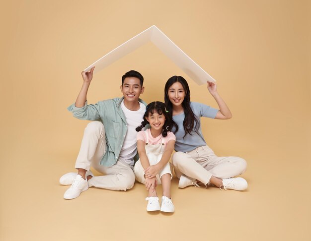 Familia asiática feliz padre y madre haciendo un techo sobre su hija