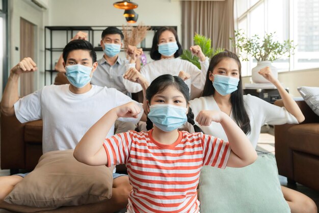 Una familia asiática fuerte y saludable que usa mascarilla protectora quirúrgica permanece en cuarentena juntos en casa distanciamiento social nuevo estilo de vida normal