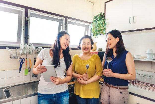 Familia asiática de pie juntos en la cocina