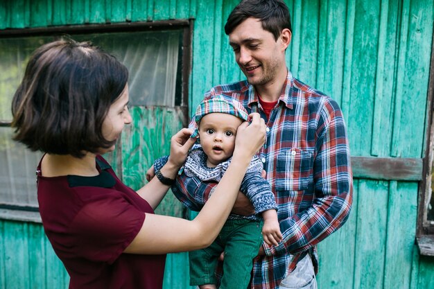 Familia con el bebé que se coloca fuera de la casa