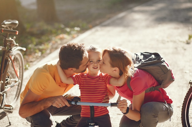 Foto gratuita familia con una bicicleta en un parque de verano