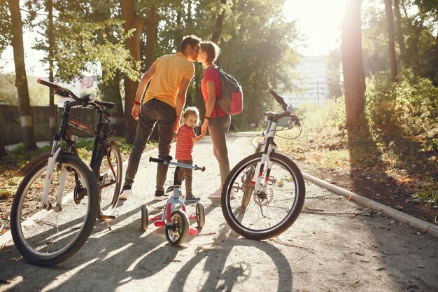 Familia con una bicicleta en un parque de verano