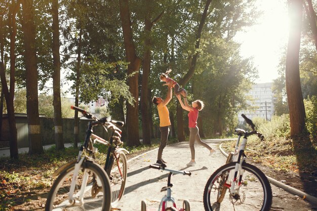 Familia con una bicicleta en un parque de verano