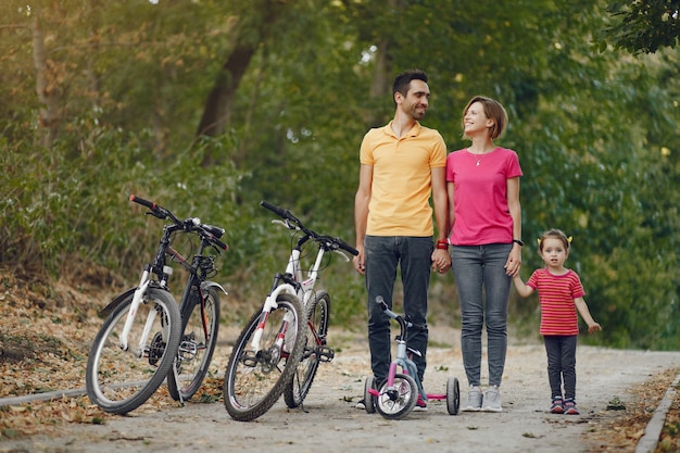 Familia con una bicicleta en un parque de verano