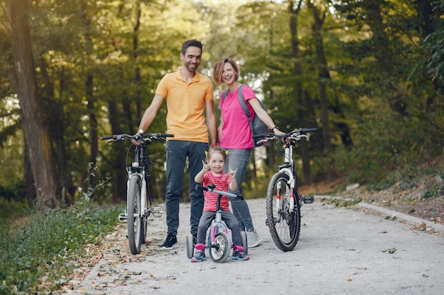Familia con una bicicleta en un parque de verano