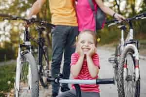 Foto gratuita familia con una bicicleta en un parque de verano