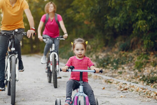 Familia con una bicicleta en un parque de verano