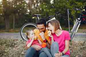 Foto gratuita familia con una bicicleta en un parque de verano