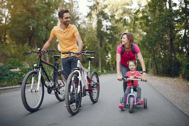 Familia con una bicicleta en un parque de verano