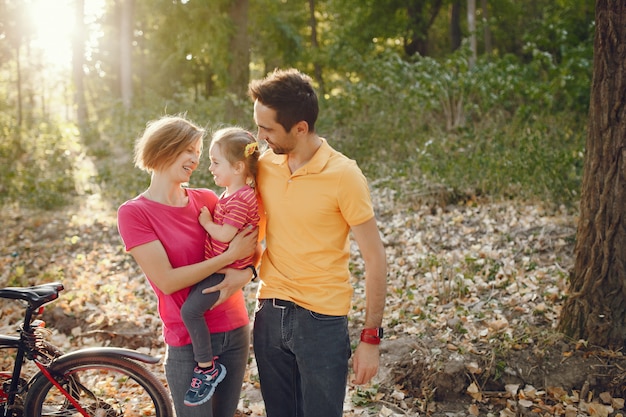 Familia con una bicicleta en un parque de verano