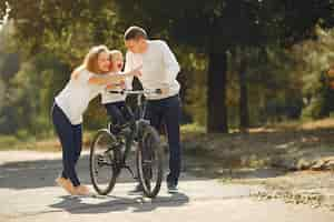 Foto gratuita familia con una bicicleta en un parque de verano