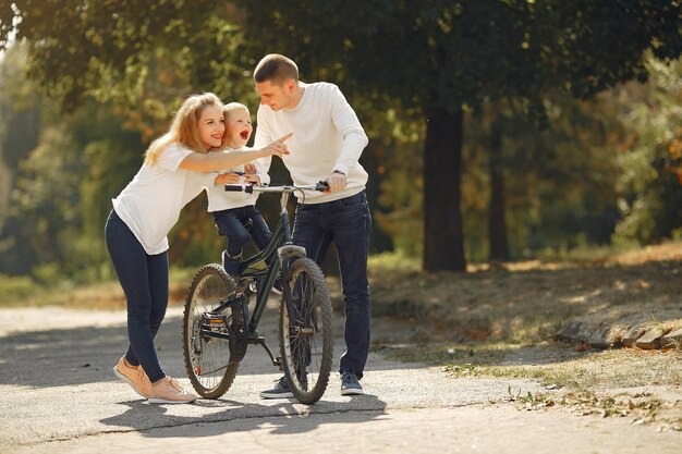 Familia con una bicicleta en un parque de verano