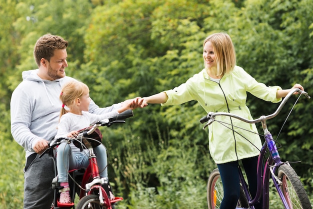 Familia en bicicleta tomados de la mano