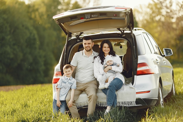 Familia en un bosque de verano junto al tronco abierto