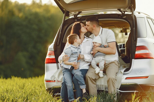 Familia en un bosque de verano junto al tronco abierto