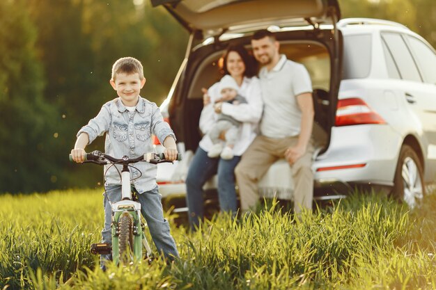 Familia en un bosque de verano junto al tronco abierto