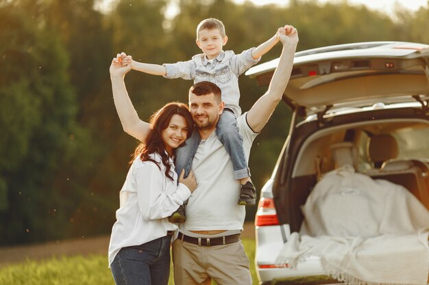 Familia en un bosque de verano junto al tronco abierto