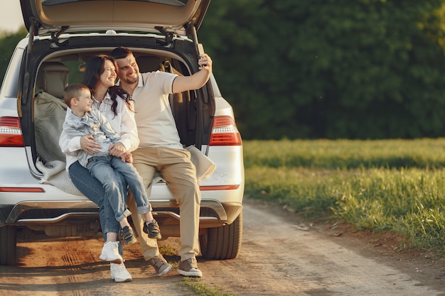 Familia en un bosque de verano junto al tronco abierto