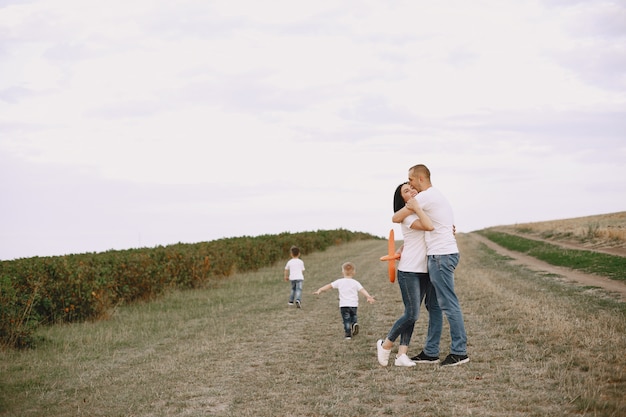 Familia camina en un campo y jugando con avión de juguete