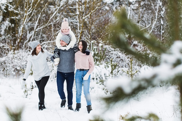 Familia caminando en el bosque de invierno