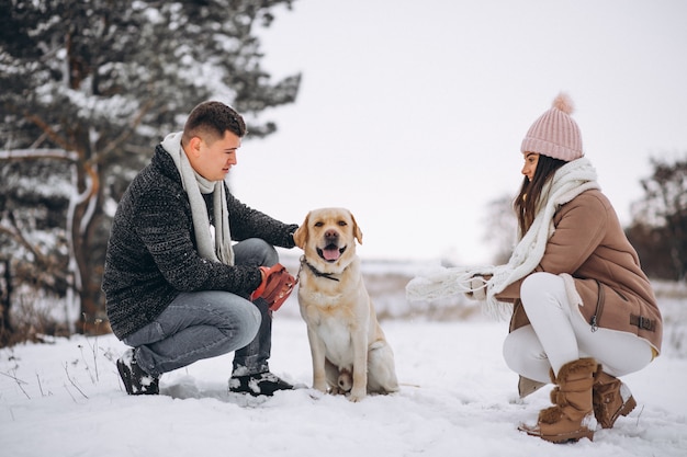 Familia caminando en el parque de invierno con su perro