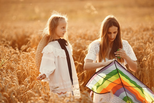 Familia en un campo de trigo. Mujer con un vestido blanco. Niño con cometa.