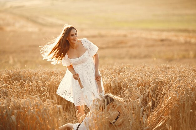 Familia en un campo de trigo. Mujer con un vestido blanco.