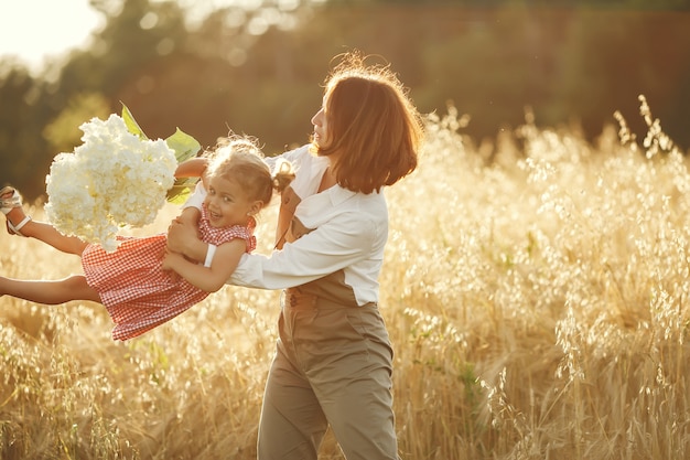 Familia en un campo de verano. Foto sensual. Pequeña niña bonita.