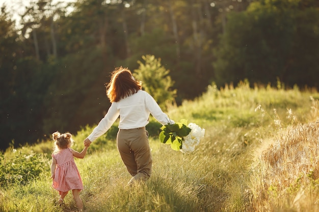 Familia en un campo de verano. Foto sensual. Pequeña niña bonita.