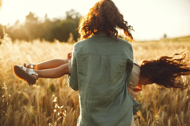 Familia en un campo de verano. Foto sensual. Pequeña niña bonita.