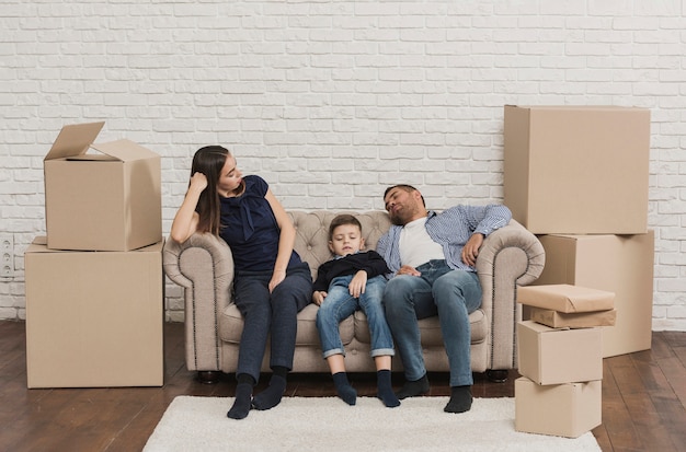 Foto gratuita familia cansada después de empacar cajas de cartón