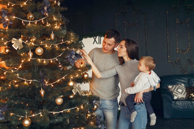 Familia en casa cerca del árbol de Navidad