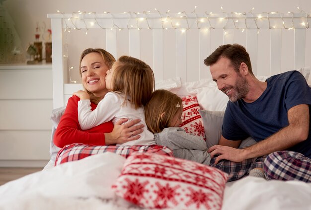 Familia celebrando la Navidad en la cama