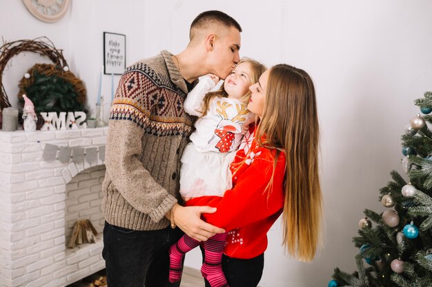 Familia celebrando navidad en casa con hija