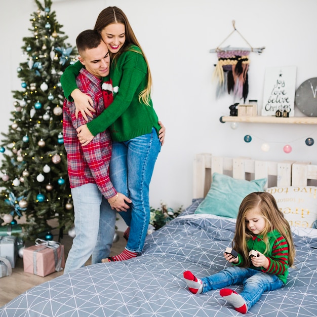 Familia celebrando navidad juntos en dormitorio