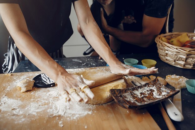 Familia cocina la masa para galletas en la cocina